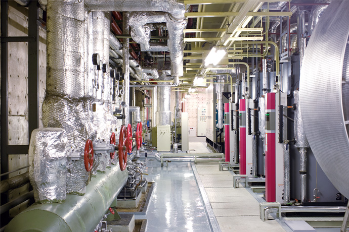 Machine room installed with highly efficient oncethrough boilers and cogeneration system as part of the project. Many visitors come to see this system.