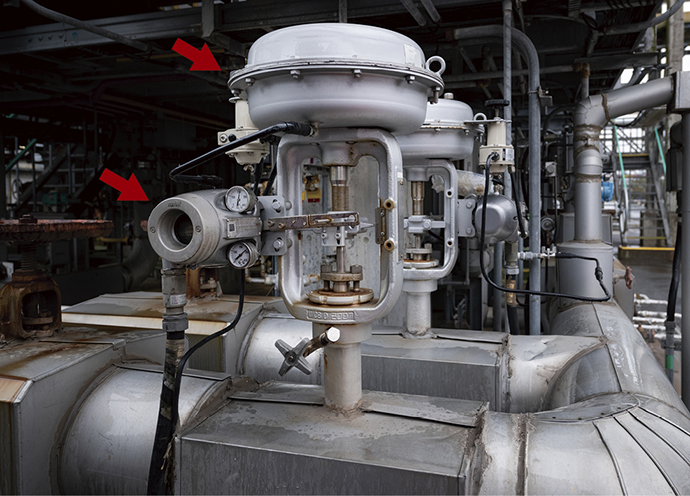 スマート・バルブ・ポジショナ 700シリーズ（左）を実装したアズビルのトップガイド型単座調節弁。熱溶解した原料を加温するために加熱炉に送り込まれる蒸気の流量を制御している。