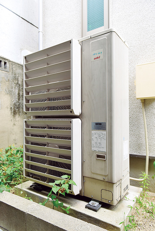 屋外の裏庭に設置された室外機。家屋全体の冷暖房を担う能力を備える。