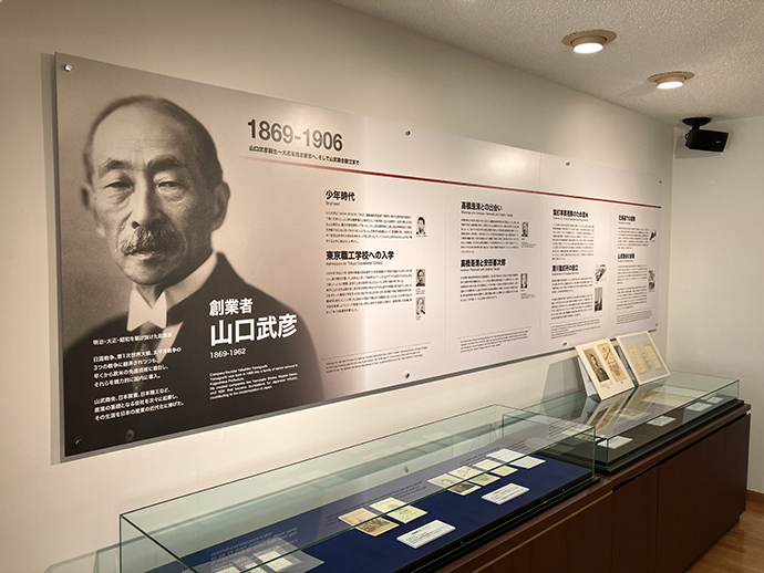 Photo exhibit panels introduce Takehiko Yamaguchi’s career. Photographs from his childhood and time in the United States are displayed, as well as passports and letters.